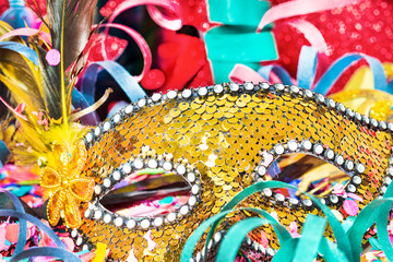 Close-up confetti and multicolored streamers with carnival mask