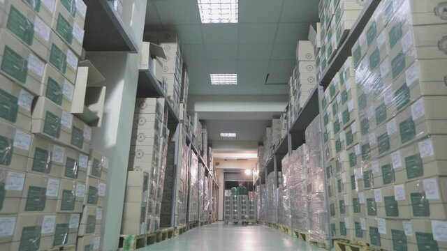 A modern warehouse in a factory. Two workers in a factory warehouse. Warehouse with boxes in a factory
