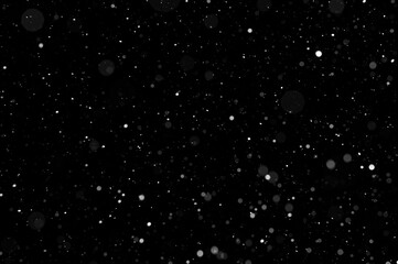 Bokeh of white snow on a black background. Snowfall - design element.