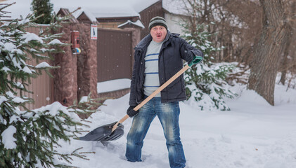 Snow collapse, man cleaning snow at winter weather with a shovel on a yard, winter trouble concept