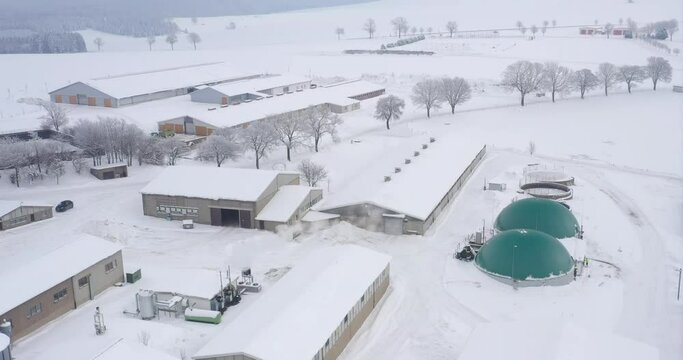 Erneuerbare Energien durch Biogasanlage auf einem Bauerngehöft mit Viehzucht im Winter - Luftaufnahme