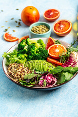 Vegetarian Quinoa bowl. Healthy breakfast or snack with detox quinoa with vegetables, avocado, blood orange, broccoli, watermelon radish, spinach, pumpkin seeds