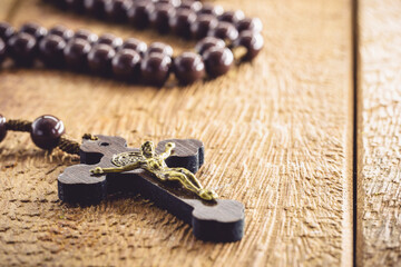 rustic wooden rosary, handmade, on wooden background, space for text