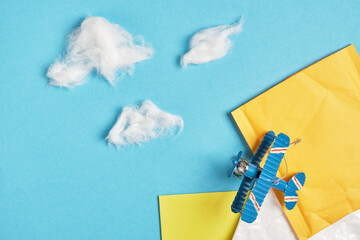 toy model of a vintage plane made of metal and several parcels on a blue background, cotton wool...