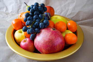 Big plate with lots of healthy fruits over paper background 