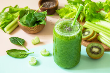 Healthy diet and nutrition, vegan, alkaline, vegetarian concepts. Green smoothie with celery, kiwi and spinach on a green  pink background.