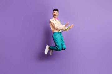 Fototapeta na wymiar Full length profile side photo of happy crazy funky man pull suspenders jump up air isolated on violet color background