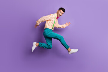 Fototapeta na wymiar Full body profile side photo of young man run copyspace wear pink bow tie jump isolated on purple color background