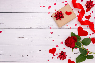 Gift, rose and red hearts on white wooden background, top view. Copyspace, a Valentine's Day concept.