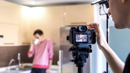 A photographer shooting a man on the kitchen