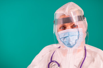 Fototapeta na wymiar Doctor with a face shield in PPE suit uniform with stethoscope on the shoulder, wearing medical protective Mask