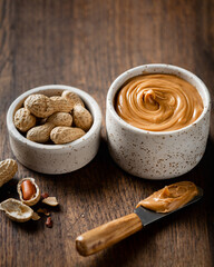 peanut butter in a ceramic bowl on wooden background