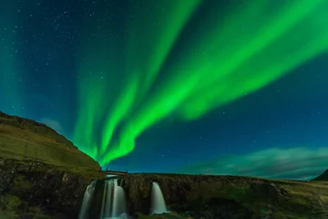 Fototapete Kirkjufell Northern lights in Iceland. Landscape full of kp5 Aurora Borealis. Amazing nightscape at Kirkjufell, scenic travel destination. Green sky full of stars.