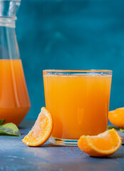 Refreshing tangerine juice in a clear glass. Tangerine slices on the table