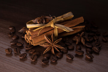 Cinnamon sticks, star anise and coffee on dark textured background