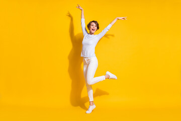 Fototapeta na wymiar Full length photo of funky charming young lady dressed white shirt dancing rising hands arms isolated yellow color background