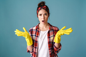 Displeased caucasian young woman in gloves holding copyspace