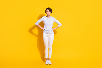 Fototapeta na wymiar Full length photo of sweet angry young lady dressed white shirt standing arms waist isolated yellow color background