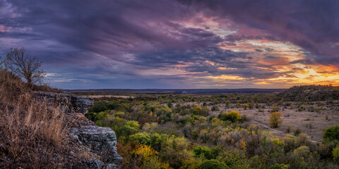 Autumn sunset over rocks and forest. Panorama