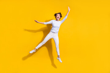 Fototapeta na wymiar Full length photo of sweet pretty young lady dressed white shirt jumping waving arm isolated yellow color background