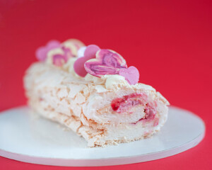Sweet roll on red background with pink chocolate hearts