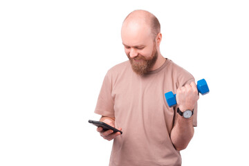 Photo of cheerful office worker man using smartphone and working with blue dumbbell.