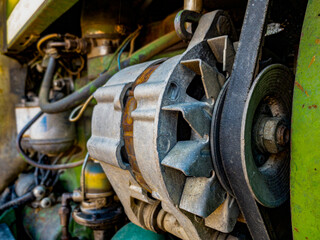 old and green tractor engine and belt, mechanics and industry