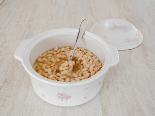 White beans cooked in a bowl of white piglet.
