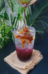 Blueberry syrup with espresso shot in a glass, placed on the table.