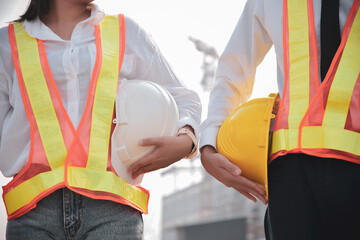 Male and female engineers holding helmets at workplaces