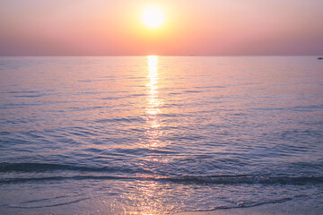 The sun rises on the sea coast. Calm water. Pink-lilac dawn. - 412921594