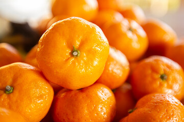 Beautiful fresh orange tangerines in a beautiful wooden tray and bokeh blur background.
