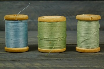 Vintage wooden spools of thread for sewing on black background 