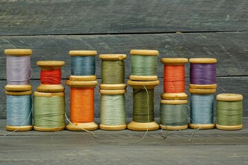 Vintage wooden spools of thread for sewing on black background 