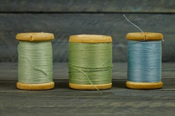 Vintage wooden spools of thread for sewing on black background 