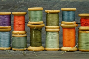 Vintage wooden spools of thread for sewing on black background 