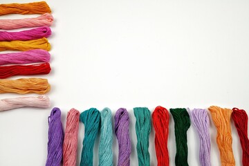 Multicolored embroidery threads on the white background
