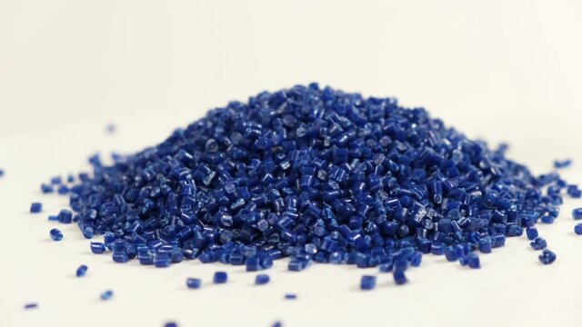 Secondary granule made of polypropylene, Dark Plastic pellets crumbles to the table . Plastic raw materials in granules for industry. Polymer resin. Raw plastic recycling concept.