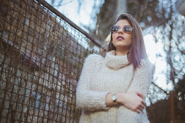 Shallow focus shot of a strong fearless woman standing beside a fence