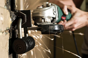 The process of cutting a large metal barn door lock with an electric saw