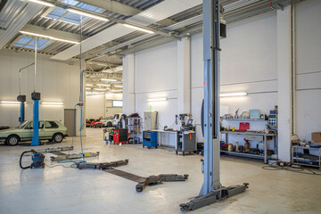in big empty car workshop there are some car lifts