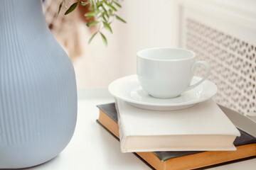 cup of coffee and books. cozy light photograph with books. White cup for tea. Still life with a book and a cup