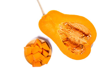 Sweet orange pumpkin isolated on a white. Cubes of pumpkin on a plate.
