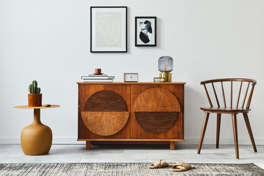 Stylish retro scandinavian living room interior with wooden commode, mock up poster frames, chiar, design stool, cacti, lamp, clock, book, decoration and personal accessories in home decor. Template.