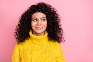 Photo portrait of curious curly girl in knitted sweater looking empty space isolated on pastel pink background