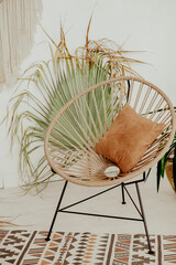 chair on the table with flowers. interior in Bali style. Wooden wicker chair. Boho style summer interior © ganusik1304