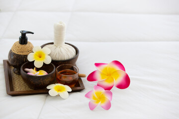Fototapeta na wymiar Set of spa treatments, natural oil, and plumeria flowers