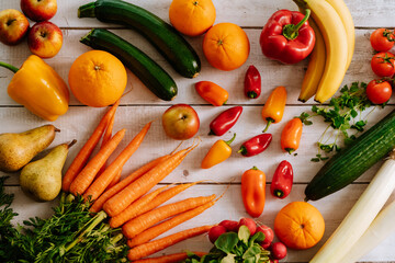 Fresh, healthy, colorful composition from various raw, seasonal fruits and vegetables, food still life on a wooden background