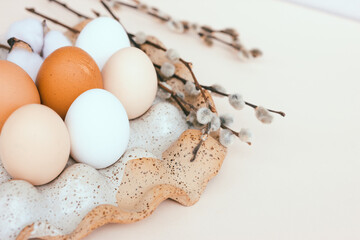 Easter unpainted chicken eggs in a ceramic egg holder. Dried flowers, beige color, place for text