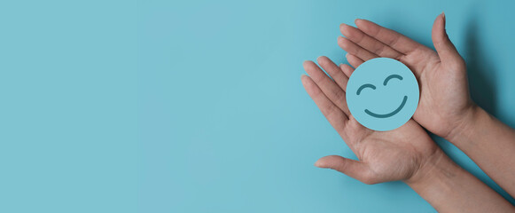 Hand holding blue paper cut happy smile face, Positive thinking, Mental health assessment , World mental health day concept